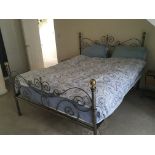 A wrought iron double bed with round brass finials. Matters and linen not included.