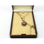 A 9ct gold pendant set with rubies and small diamo