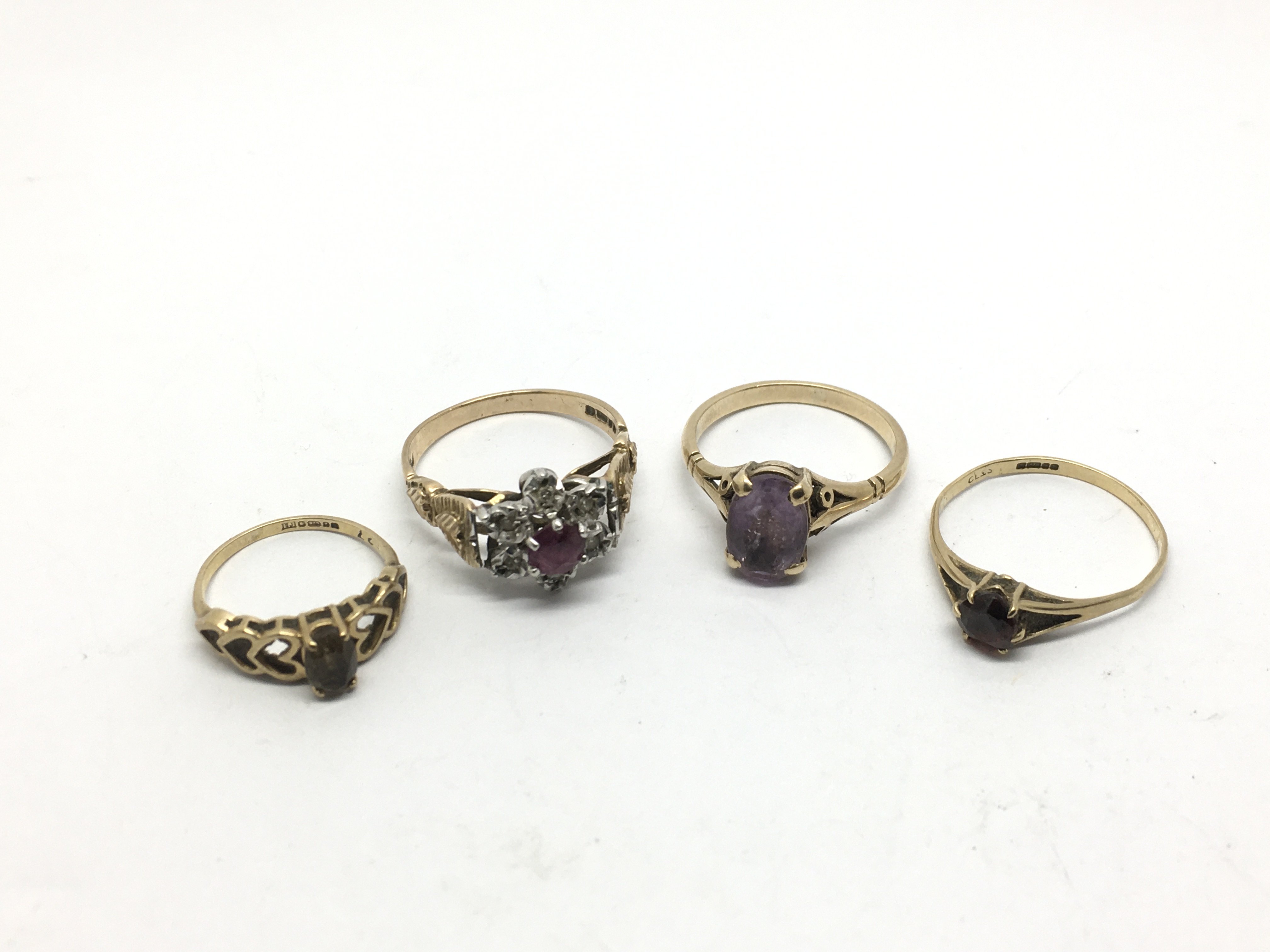 Four gold rings set with stones comprising ruby, d