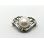 An 18ct white gold pearl and diamond pendant, appr