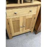 A modern solid oak cabinet with a single drawer an