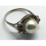 A white metal (possibly gold) ring set with a pear