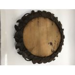 A Black Forest oval frame carved with foliage deco