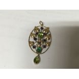 A 9carat gold oval open floral pendent set with gr