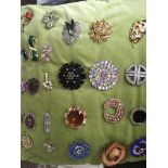 A cushion containing 25 brooches.