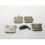 Four silver stamp holders and a charm.