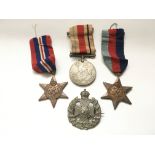 Three WW2 GB medals plus a military badge marked W