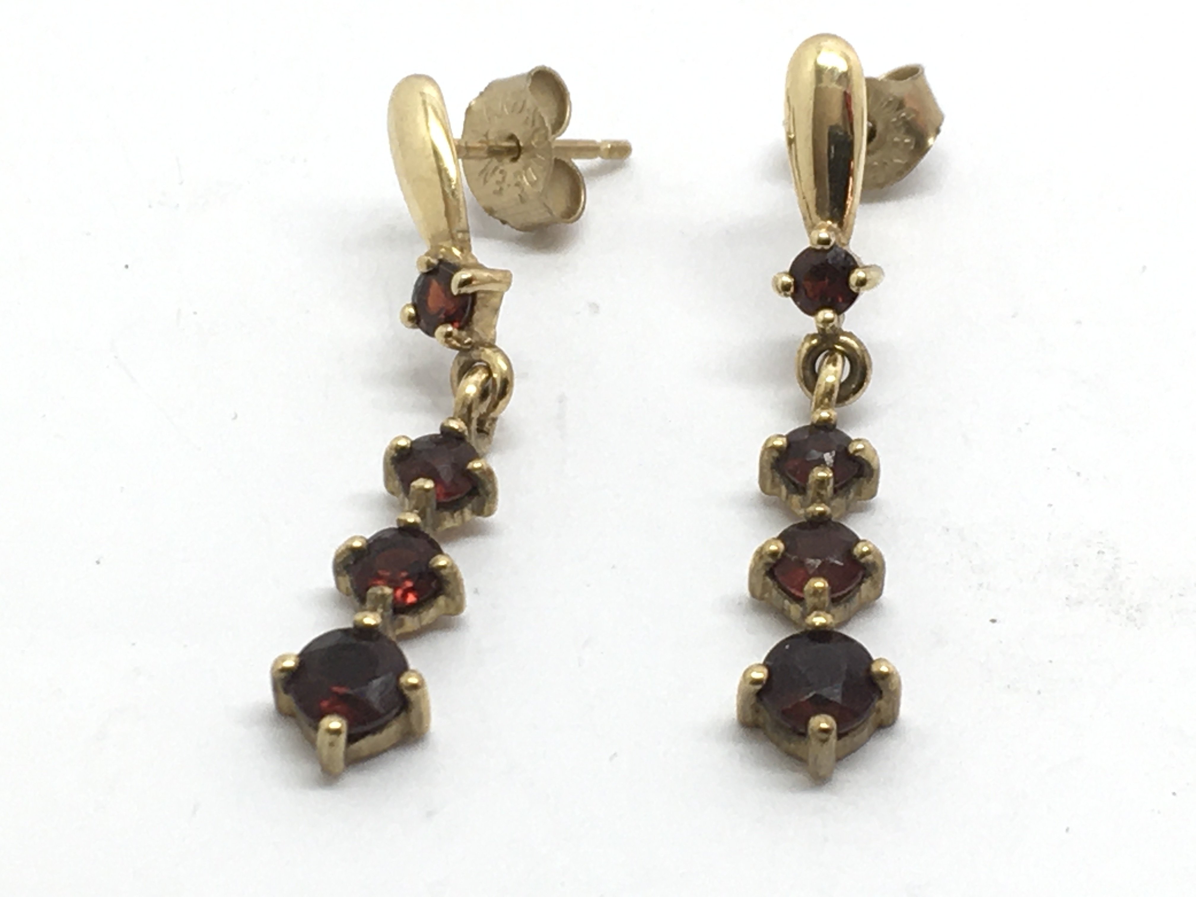 A pair of gold drop earrings set with garnets, app