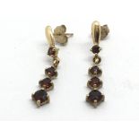 A pair of gold drop earrings set with garnets, app