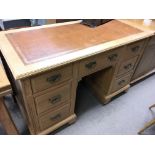 A late Edwardian satin walnut desk with a leather