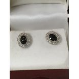 A pair of white gold stud earrings with central bl