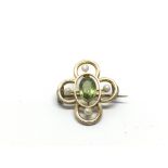 A 9ct gold brooch set with a green peridot and fou