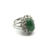 An 18ct white gold ring set with a central green s