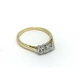 An 18carat gold ring set with a row of three brill