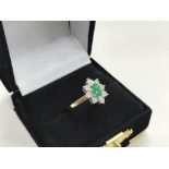 A 9ct gold, emerald and diamond cluster ring.