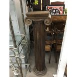 A wood classical column with ionic scroll volutes.