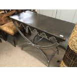 A modern design metal console table with a bronzed metal top and shaped appron.