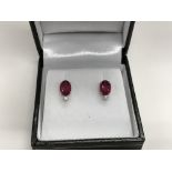 A pair of platinum, treated ruby and diamond stud