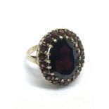 A gold ring set with a large garnet surrounded by