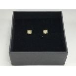 A pair of yellow gold and diamond solitaire studs,