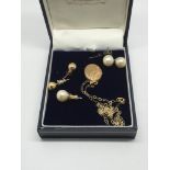 A small gold locket, a pair of pearl earrings and