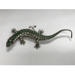 A sterling silver and stone set lizard brooch.