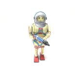 A Tinplate Battery yellow spaceman with silver helmet and gun.