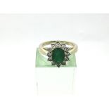 A 9ct gold oval cut emerald and diamond cluster ri