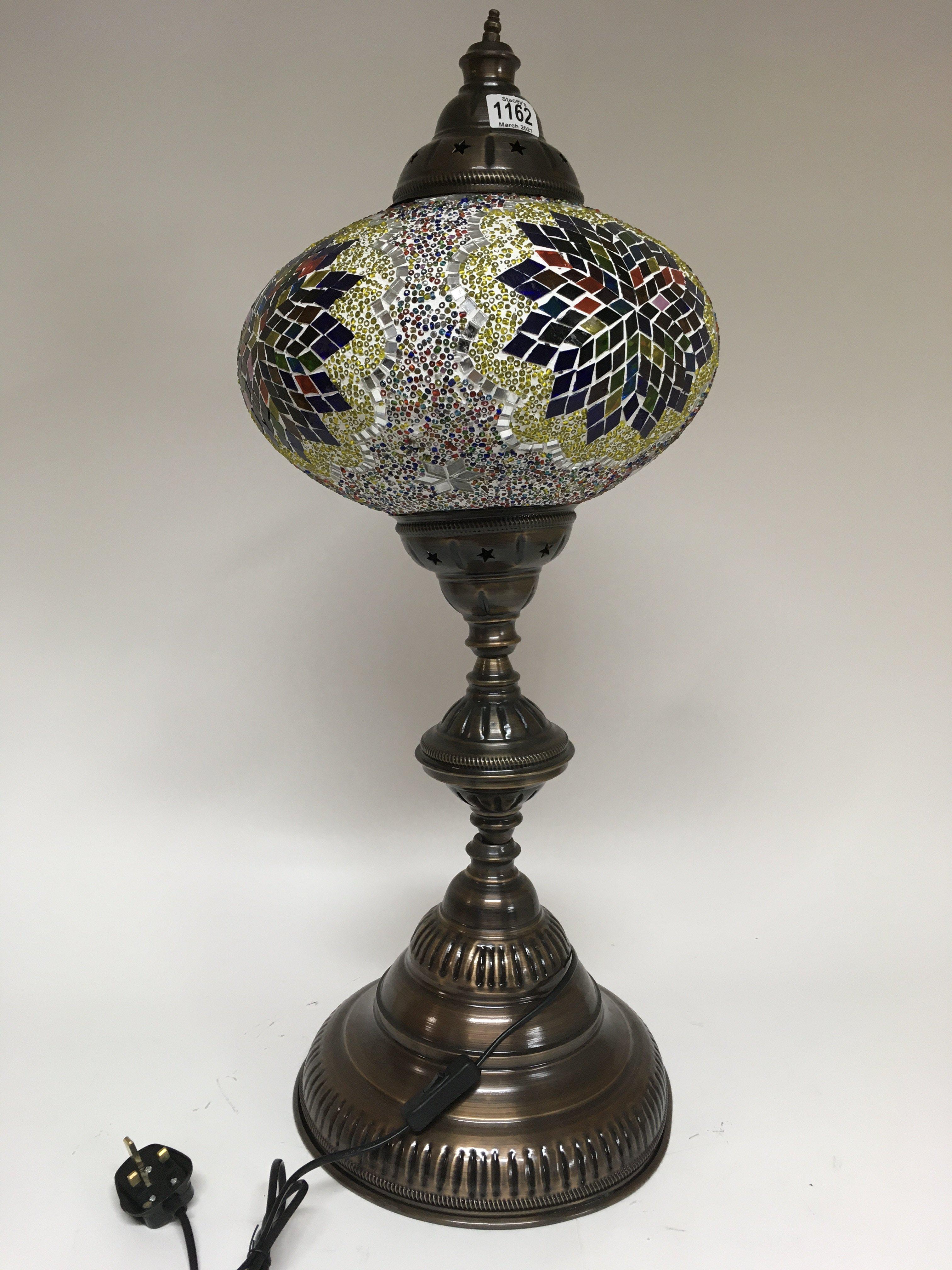 A large Moorish style lamp on large circular base.