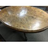 A Victorian walnut loo table the oval inlaid top a