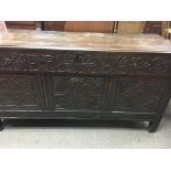 A oak blanket chest the hinged lid above a carved