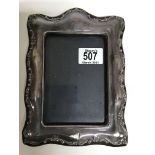 A modern silver picture frame with floral scrolled