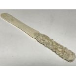 An ivory carved paper knife with intricate flower