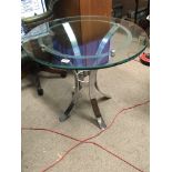 A modern design chrome and glass table with a circular top on splayed supports. Diameter 77cm.