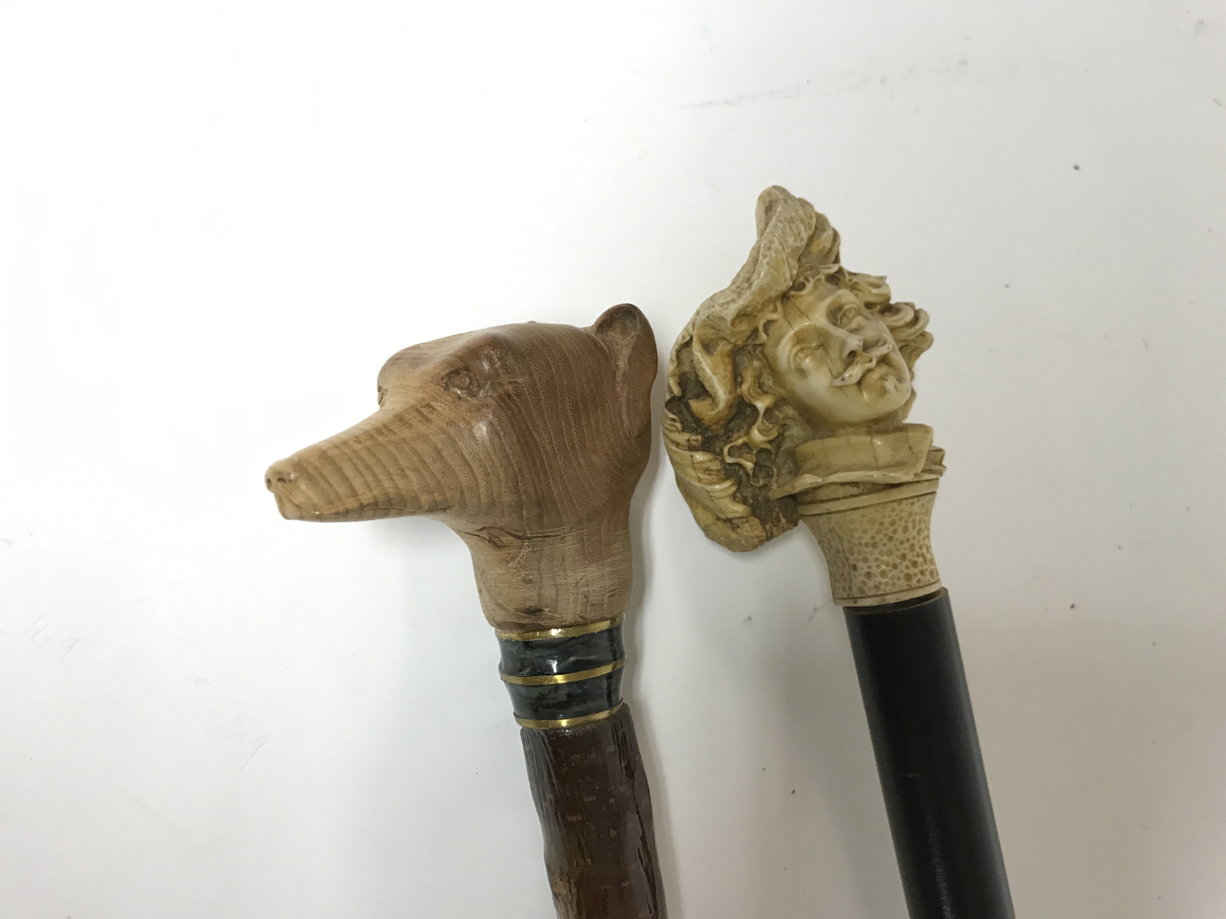 Two walking sticks. 1 with a carved dogs head (hei
