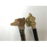 Two walking sticks. 1 with a carved dogs head (hei