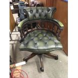 A Green leather button down upholstered office chair.