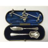 A pair of hallmarked silver knife rests, Chester 1910and a cased silver spoon and knife, Sheffield