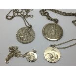 Four silver St Christopher pendants on chains.