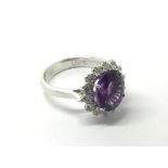 An 18ct white gold oval cut amethyst and diamond c