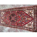 A hand knotted Hamadan rug with a central medallion and floral pattern on a red ground. 100cmx200cm