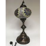 A large Moorish style lamp on large circular base.