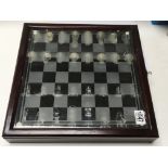 A glass chess set in wooden case