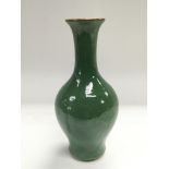 A green ceramic vase with an elongated neck and a