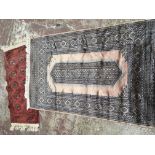 Two hand knotted rugs a small Afghan rug with a red field 109cmx52cm and one other wool