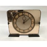 An Art Deco peach mirrored clock. Height 16cm widt