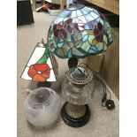 An oil lamp with a clear glass reservoir plus two Tiffany style table lamps (3).