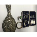 A silver hand mirror together with a manicure set