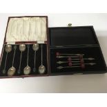 A cased set of silver cocktail sticks and a cased