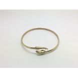 A gold bangle, the ends in the form of a dolphin,